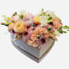 Heart-shaped box filled with pastel mixed flowers