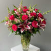 Bold stargazer lilies and rich pink or red roses collide in a