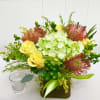 This fun colored cube has hydrangea, pin cushion protea and roses. 