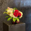 The perfect posy vase holds a cluster of red roses accented by