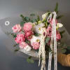A luxurious winter bouquet featuring soft pink blooms, delicate white orchids, and