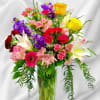 Beautiful arrangement with assorted flowers and greenery one side 