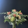 An elegant arrangement filled with roses, spray roses, baby's breath, lilies, and