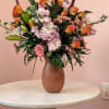 A stunning display unfolds vibrant orange roses with scented Stock flowers Interspersed