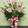 Twelve, beautiful, perfect Roses are arranged in a crystal clear glass vase.