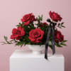 Classic red roses with fresh greenery, accented with a black ribbon and