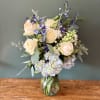 This elegant white and blue floral arrangement features fresh white and blue