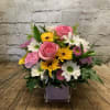 A cheery mix of daisies, pompons, roses and asters in a pink
