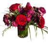 A vibrant blend of red roses, hot pink stock, purple anemones, and