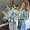The bouquet showcases an exquisite arrangement of flowers in varying shades of