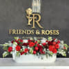 Gorgeous vase arrangement of fresh flowers, Christmas balls, and pillar candles for