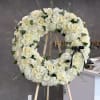 This stunning  round funeral bouquet features two dozen roses, artfully arranged