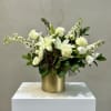 An elegant white and green arrangement featuring textured kale, white roses, delphinium