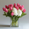 A stunning harmony of soft pink tulips and pristine white hydrangeas, this