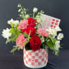 Charming flower arrangement in a red and white checkered pot with hearts