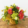 This arrangment is presented in a yellow ceramic vase. It features tropical