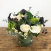 This arrangement features succulents, calla lily, white roses and lush greens. 