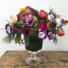 This arrangement are presented in a clear pedestal vase. It's a very