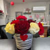 A cheerful mix of mounded roses and carnations designed in a cute