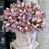 This arrangement is a soft, modern blend of tulips, lilacs, and roses
