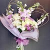 An elegant, hand-tied wrapped bouquet with a soft, romantic palette dominated by