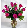 Our beautiful hot  pink roses are designed with seasonal greenery which