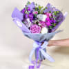 A very full styled bouquet wrapped in deluxe paper to create a