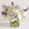 Floral arrangement featuring blues , whites and creams.

*Vase/container may vary depending on