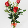 A trio of Roses in a bud vase with filler and greens.