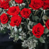 Two dozen gorgeous red roses artfully designed in a tall vase with