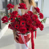A breathtaking composition of deep red roses, vibrant gerbera, romantic anemones, and