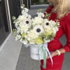 An exquisite arrangement of creamy white roses, delicate anemones with deep contrasting