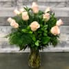 One dozen premium light pink roses arranged in a clear vase. Accent