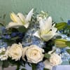 A low arrangement of high end flowers in blues and white and