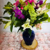 Blue glass vase with an assortment of fragrant flowers. A floral arrangement