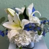 A low compact arrangment of high end blue and white flowers. 
