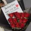 Romantic bouquet featuring 12 fresh red roses, wrapped in a modern newspaper-style