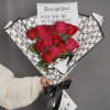 Romantic bouquet featuring 12 fresh red roses, wrapped in a modern newspaper-style