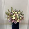Light pink and lavender roses with larkspur and white spray roses.