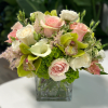 Imagine a charming small flower arrangement in a square crystal vase, showcasing