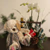  A wooden basket filled with champagne, chocolates, teddy bear and orchids
