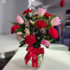A charming Floral arrangement featuring fresh tulips paired with delicate carnations, wax