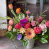 This arrangement is uniquely crafted with sunset feels and beautiful florals. Florals