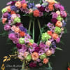 This open heart made with green hydrangea, purple roses, carnations , daosy.