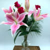 This delicate glass vase is filled with Oriental Lilies and red roses.