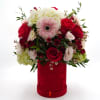 A romantic arrangement of red roses, blush blooms, and white hydrangea with