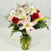 Featuring a combination of pink lilies, red roses, pink carnations, white daisies