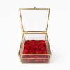 A modern keepsake of timeless romance. This gold-framed glass box filled with
