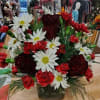 A short full arrangement with a variety of Red and White Flowers.