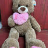 Measuring 36" tall, this super soft bear carries a light pink heart